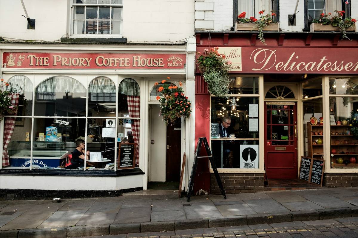 the front of a coffee shop with a woman sitting in the window, Digital Marketing Agencies, Small Businesses